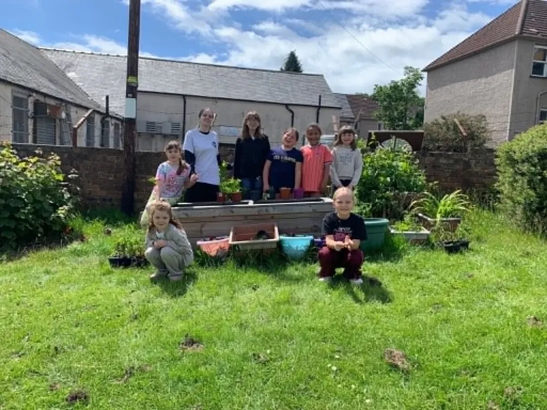 The group gathered outside around their raised planter after a gardening session